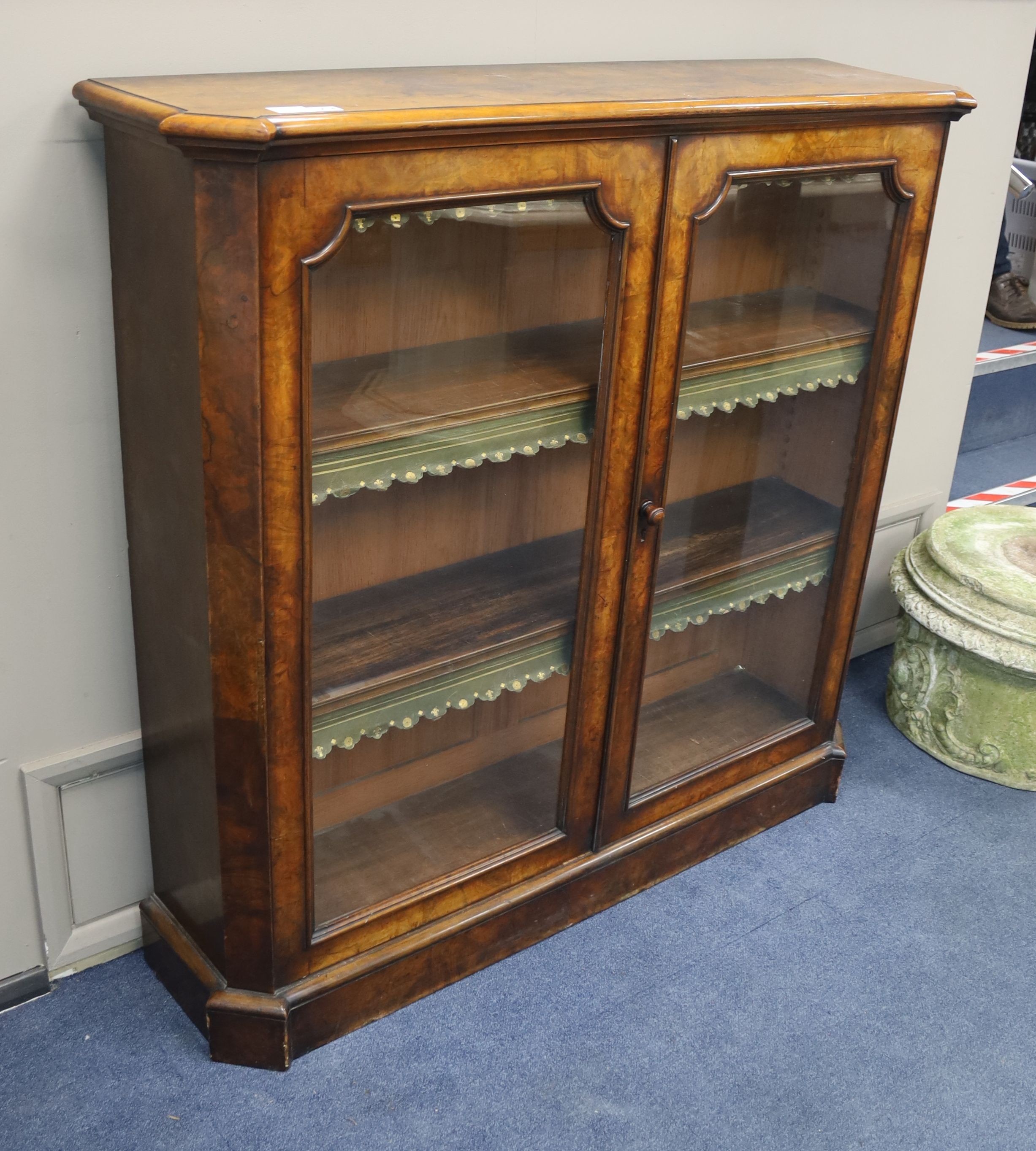 A Victorian walnut veneered bookcase with twin panelled glazed doors, length 126cm, depth 33cm, height 122cm